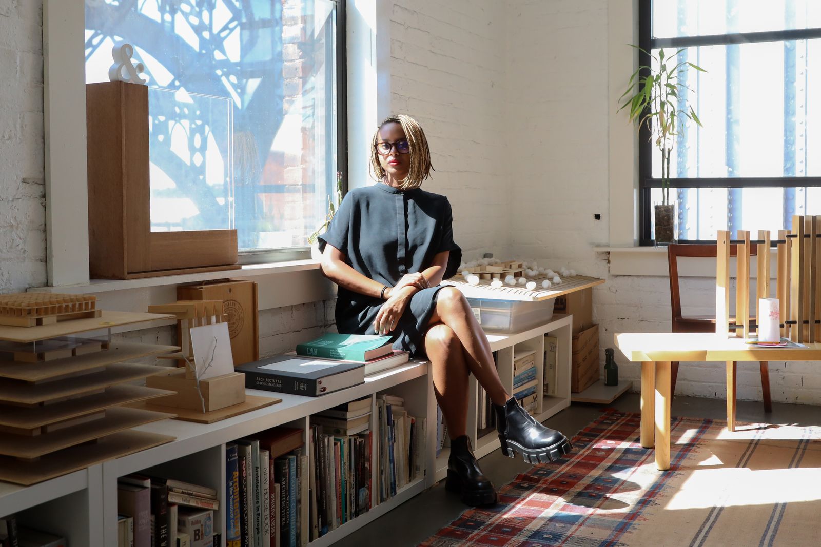 Image may contain Person Sitting Plant Adult Book Publication Home Decor Rug Accessories Glasses and Desk